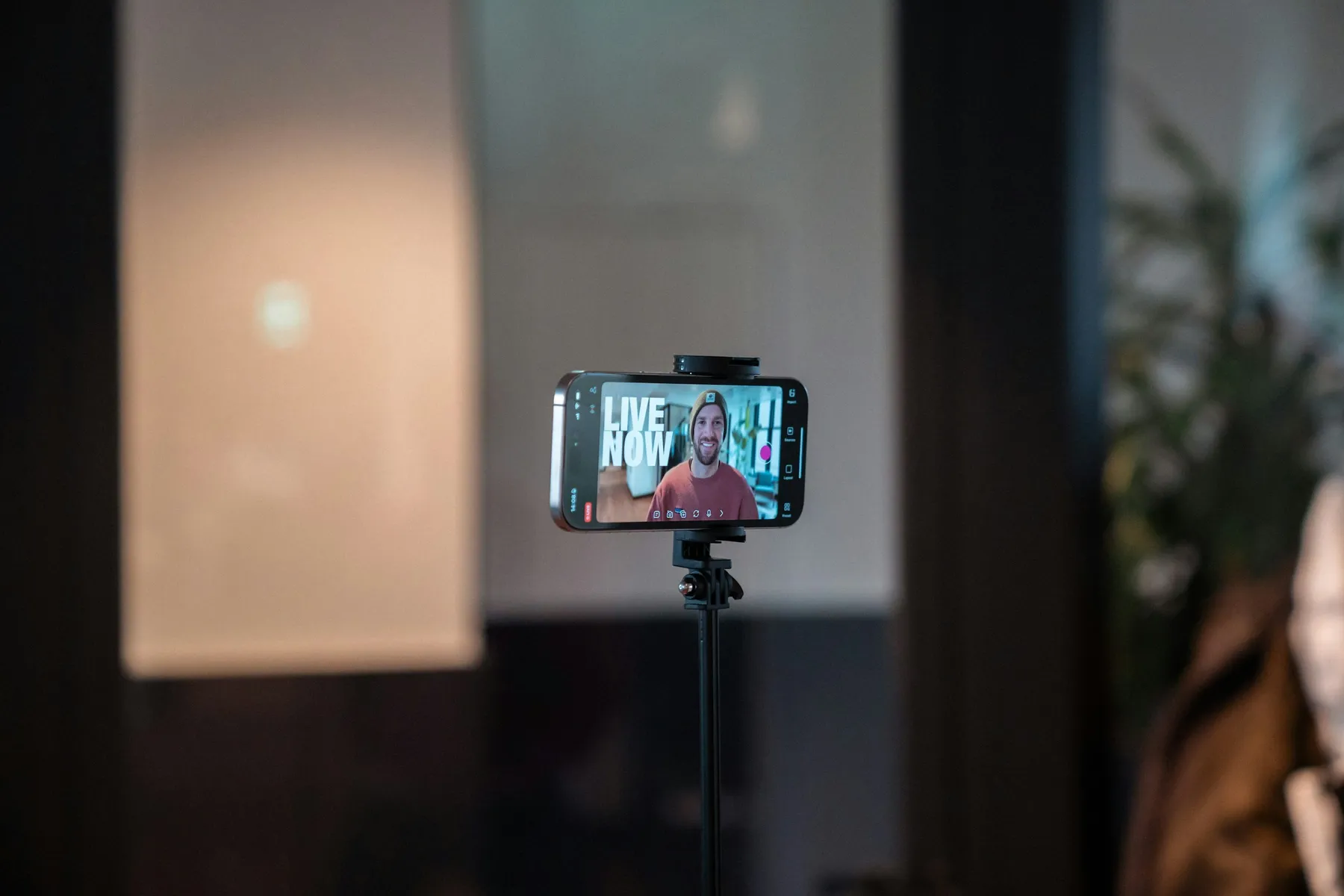 A phone mounted on a tripod recording a live social broadcast